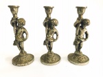 Terno de antigos castiçais confeccionados em metal espessurado a prata representando "putinos com cornucópias". Med.: 22 cm.