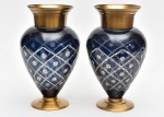 Par de lindíssimos vasos decorativos confeccionados em cristal double azul, lapidado, com bases e bocas em metal dourado. Med.: 28x15 cm.