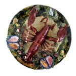 Medalhão em faiança portuguesa Bordalo Pinheiro esmaltada com grande lagosta, conchas e mariscos em relevo, marcado no fundo. Diametro: 32,0 cm