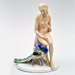 Grupo escultórico Art Decó em porcelana alemã representando nu feminino com pavão, marcado no fundo. Meds: 29,0 cm x 21,0 cm