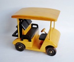 Carro de golfe feito em madeira com ricos acabamentos incluindo na traseira duas esculturas com taco de golfe.