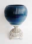 Centro de mesa em porcelana azul petróleo em forma de bola frisada com pés em resina ricamente trabalhada com folhagens. Medidas 14x28 cm