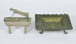 Interessante conjunto de uma cigarreira em forma de caixa com soldado no tampo e um cinzeiro em metal prateado. Marcas de uso. No estado.  Medidas: Altura - 10,0 cm; Largura - 9,5 cm; Profundidade - 3,0 cm.