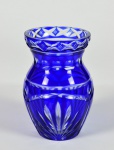 Pequeno vaso de flores em cristal europeu azul com lapidações de palmas. Marcas de uso. No estado. Medidas: Altura - 14,0 cm; Diâmetro - 7,0 cm. Obs: Possui bicados na borda.