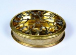 Pequena caixa de metal dourado e "pérolas". Tampa vazada simulando ramos com pérolas. Sem marca de fabricação aparente. Med. 3 cm de altura x 10 cm de diâmetro. Marcas do tempo. Desgaste na douração. Pequenas faltas. Faltam algumas pérolas. No estado.