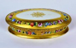 Elegante caixa de origem francesa de porcelana.Tampa com guarnição de metal dourado, adornada por pintura a mão dourada e floral. Pintados à mão.Marcas na base.  Med. 5 cm de altura x 11 cm de largura x 20 cm de comprimento. Marcas do tempo. No estado.