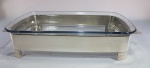 Travessa refratária em vidro temperado com suporte em metal espessurado à prata. Med.  40 x 20 x 8 cm