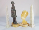 Lote com 4 peças egípcias sendo 2 obeliscos, um busto e uma escultura em metal. Altura do maior: 22 cm