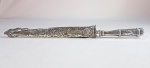 FACA GAUCHA - CORNETA - faca em metal branco, bainha cinzelada com folhas de Acanto e motivos fitomórficos. Lâmina em aço inox. Med. 31 cm.