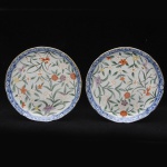 Par de pratos  em porcelana chinesa decorada com motivos  florais. Borda azul com volutas e flores em branco. Diâmetro 19 cm.
