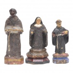 Três imagens em miniatura em madeira, sendo São Benedito, Santo Antonio e  e uma santa (no estado). Faltam mãos e menino. Medidas: 14, 12 e 11 cm.