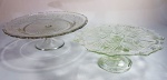 Dois antigos pratos altos para bolo ou sobremesa em vidro moldado, sendo um branco e outro esverdeado. Medidas: 30 x 10 cm e 24 x 10 cm