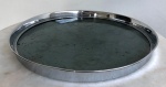 Bela bandeja de serviço, bordas de metal prateado e fundo de vidro. Med. 38cm de diâmetro.