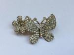 BIJUTERIA FINA- Lindo broche em metal dourado, representando borboleta e flor. Cravejado por strass. Med. 4cm