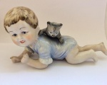 Lindíssima escultura em biscuit representando criança brincando com gato. Med. 18cm