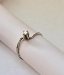 Belíssimo anel solitário em ouro branco, designer retorcido, cravejado por bela pedra central em brilhante. Aro. 19 