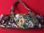 Clássica bolsa em cetim, estampada com flores, bordada com miçangas. Fecho em metal. Med. 41x17cm