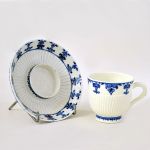 Xicara e pires em porcelana francesa Saint Cloud em `soft paste` (pasta mole), azul e branco, decorada em `Lambrequin`, cerca 1710,  xicara com marca `t S.C T h` e pires com a marca do sol. 