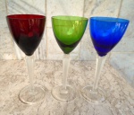 Tres taças altas de cristal com sonorização no cristal , coloridas  ( azul, verde  e rubi ) hastes facetadas e base circulares translúcidas . Altura 22 cm.