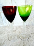 Duas taças altas de cristal com sonorização no cristal , coloridas  (  verde  e rubi ) hastes facetadas e base circulares translúcidas . Altura 22 cm.