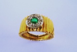 JÓIA : Anel em ouro 18 K , com trabalhos plissados em lindo design ,  tendo ao centro  pedra esmeralda circundada por pequenos diamantes . Aro 18 e peso .5,5 g