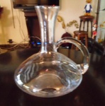 Decanter em cristal translúcido com alças , provavelmente sem uso , medindo 21 cm de altura e 24 cm de base