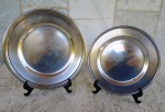 Duas salvas lisas, uma francesa com frisos nas bordas  da marca CHRISTOFLE com contraste e numeração , medindo 17 cm e outra em PRATA também lisa marcada STERLING com diâmetro de 15 cm. Peso aproximado da prata: 90g.