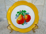 WURTTEMBERG -  Alemanha - Prato em porcelana decorativo , esmaltado em fundo branco e vitrificado com bordas recortadas e larga faixa no tom amarelo ouro . Ao centro pintura de penca com frutos. Diâmetro 21 cm.