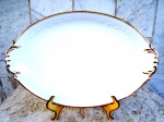 EMILE BOURGEOIS - 1857/1934 - PARIS - Linda travessa oval funda , esmaltada na cor branca e vitrificada com ornamentação em alto relevo. Contornada por forte friso em ouro. Medidas 36 x 24 x 5 cm.