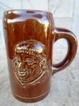 Grande caneco Franciscano em faiança esmaltado na cor marrom e vitrificado com rosto de Frade em alto relevo. peça original da década de 70. pertenceu ao restaurante Franciscano em São Paulo . Altura 18 , base 10 cm.