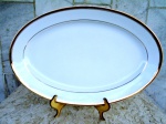 BRENAND - RECIFE - BRASIL - GRANDE TRAVESSA oval em porcelana esmaltada branca e vitrificada com  frisos em ouro e filetada na faixa também com ouro . Porcelana com Brasão da BRENAND. Comprimento 40 cm ( quarenta ) x 26 cm.