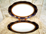 DUAS travessas ovais em porcelana branca com faixa em ouro e bordas em azul cobalto com ornamentação em ALTO RELEVO de ramagens em ouro. Marcado COBALTO - Gravação legítima - Porcelana Schimid - Santa Catarina - Brazil . Uma funda medindo 30 x 20,5 x 6 cm e outra medindo 26 x 15,5 x 4 cm.