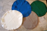 Vinte e quatro souplais de tecido fino para proteção da mesa e base para pratos , sendo 6 no tom azul petróleo, 6 verde musgo ,6 castor e 6 no tom creme. Medidas :Diâmetro 32 cm