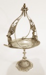REED AND BARTON ( EUA) - Antiga cesta Art Noveau em metal espessurado a prata com querubins sobre Coluna central. Alças cinzeladas com delicadas margaridas. Marcas do tempo. Med. 34 x 25 cm.
