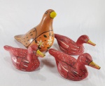 Lote com 4 esculturas no formato de aves, sendo 3 patos esculpidos em bloco de madeira policromada e uma pomba em cerâmica esmaltada. Medida do maior: 21 cm