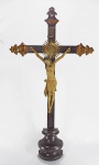BAHIA - Séc. XIX - Grande crucifixo de pousar em jacarandá, ponteiras com realces a ouro e  detalhe em metal dourado. Cristo em madeira policromada com desgastes naturais. Med.  70 x 38 cm.