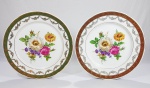 Par de pratos em porcelana Real, decorados com bouquet de flores campestres ao centro, guirandas e arabescos em forte douração. Med. 23 cm