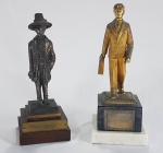 Dois troféus de Homenagens a Santos Dumont, um com placa com dedicatória ao Brigadeiro Paulo Salema. Bronze, madeira, mármore e banho de ouro. Um deles assinado no verso com as iniciais E.V.R. Altura 26 e 24 cm