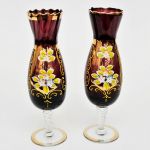 Par de copos em vidro veneziano na cor ametista com pé em gomado torcido, com pintura floral sobre fundo dourado. Alt: 25,0 cm