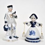 2 figuras em porcelana européia representando casal de camponeses, decorados em azul e branco com detalhes em dourado. Alt: 17,0 cm 
