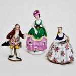 3 esculturas em porcelana alemã, sendo um casal e uma dama. Alt: 9,0 cm