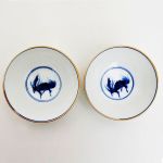 Par de bowls em porcelana chinesa celadon com pintura de dragão em azul e branco em reserva no interior, marcados no fundo. Meds: 4,5 cm x 11,0 cm