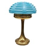Luminária de mesa no estilo Art Decó com pé em bronze com relevo de elementos fitomorfos, cúpula em vidro opalinado azul com faixas gomadas em relevo. Meds: 48,0 cm x 31,0 cm