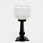 Luminária de mesa Art Decó com pé em ferro forjado, cúpula em vidro opalinado branco com grandes gomos e degrau de discos. Alt: 51,0 cm
