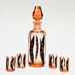 Licoreira com 4 copos Art Decó em cristal da Bohemia, corpo multifacetado na tonalidade salmão com `overlay` preto em faixa elíptica. Alt: 24,5 cm licoreira