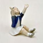 Escultura de menina sentada em porcelana dinamarquesa Royal Copenhagen. Altura: 11,5 cm