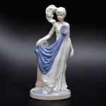 Escultura em porcelana europeia representando dama com vestido, marcada no fundo. Altura 31,0 cm