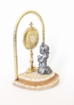Antiga escultura representando Eucaristia com ostensório adquirida em Portugal em resina e metal, com menina espessurada a prata, medindo aproximadamente 10 cm