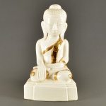 Escultura de porcelana chinesa branca representando Buda com suas orelhas longas representando compreensão. Apresenta-se sentado em gesto de Bhumisparsa Mudra que simboliza o fato de que a Terra testemunhou a iluminação de Buda sob a árvore de Bodhi. Alt. 52 cm.