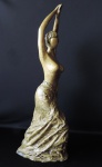 Belíssima escultura em forma de figura feminina, feita em bronze polido maciço. Peça de grande medida e bem pesada.. Medidas de 70cm x 28cm. Obs. Sem base.